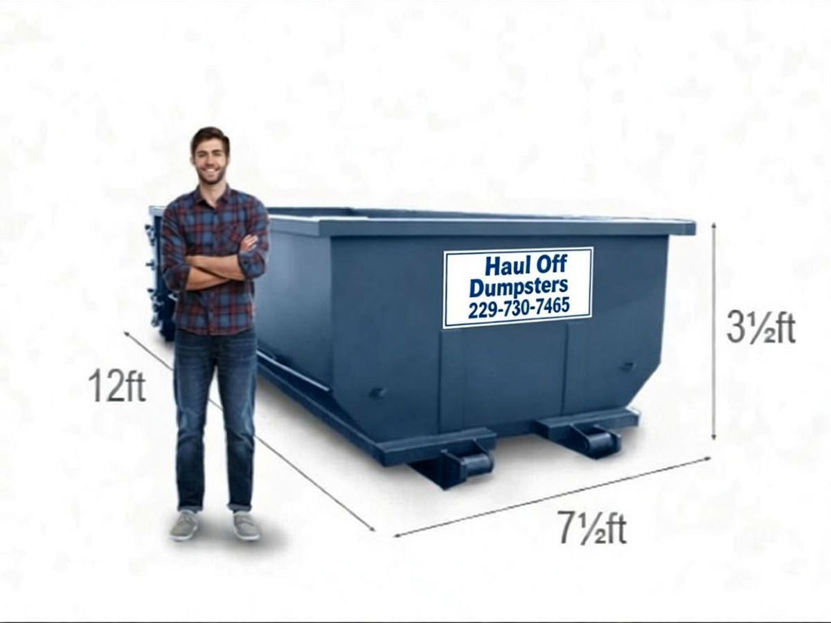 A dumpster shown beside a person for scale, with the Haul Off Dumpsters sign plate on its side, used here only as a general size reference